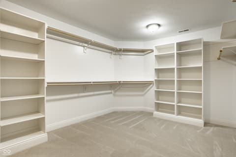 Primary bedroom at 13429 Boxelder Court, Carmel, IN — Spacious walk-in closet with extensive built-in storage.