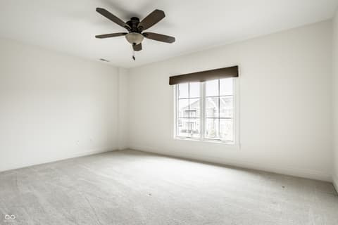 Bedroom at 13429 Boxelder Court, Carmel, IN — Bright spacious bedroom with large windows and ceiling fan.