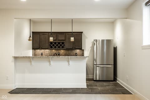 Kitchen at 13429 Boxelder Court, Carmel, IN — Modern kitchen with dark cabinetry and granite counters.