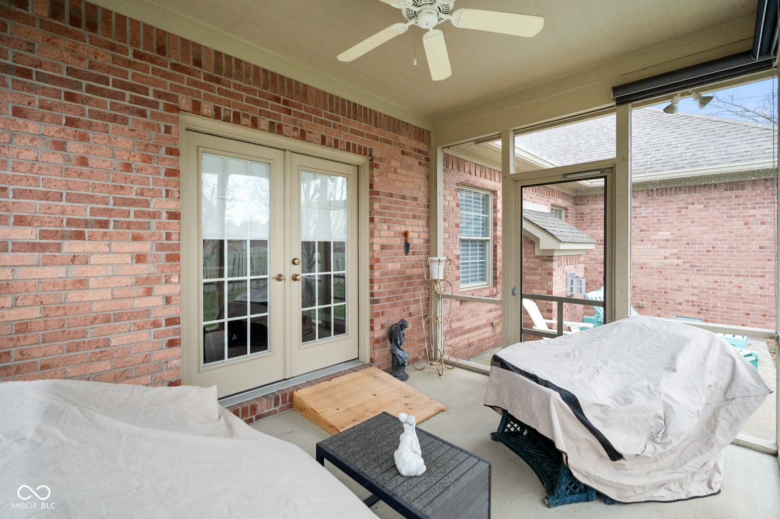 Bright screened porch with brick and multiple windows.