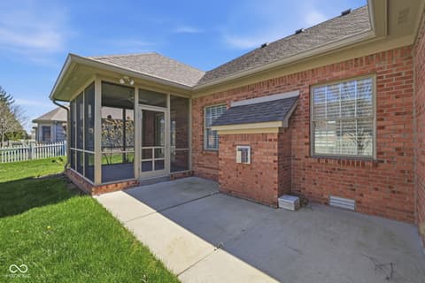 Backyard at 10122 Pyrite Court, Noblesville, IN — Charming screened porch with brick home and spacious patio.