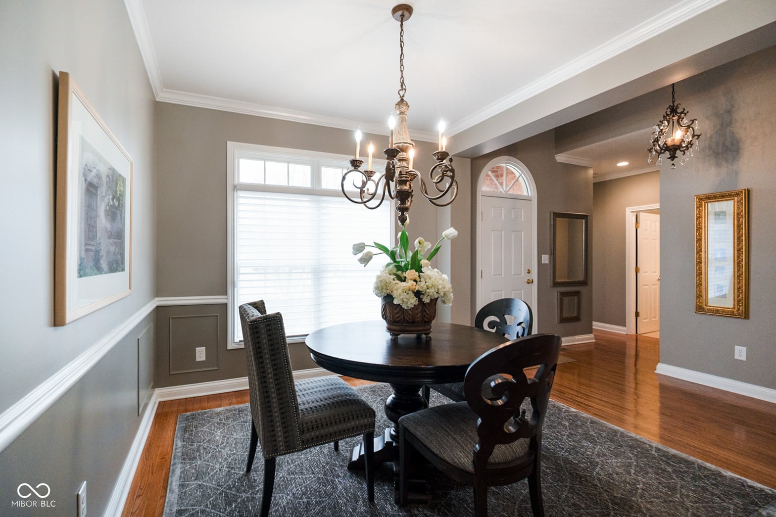 Elegant dining room with hardwood floors and crown molding.