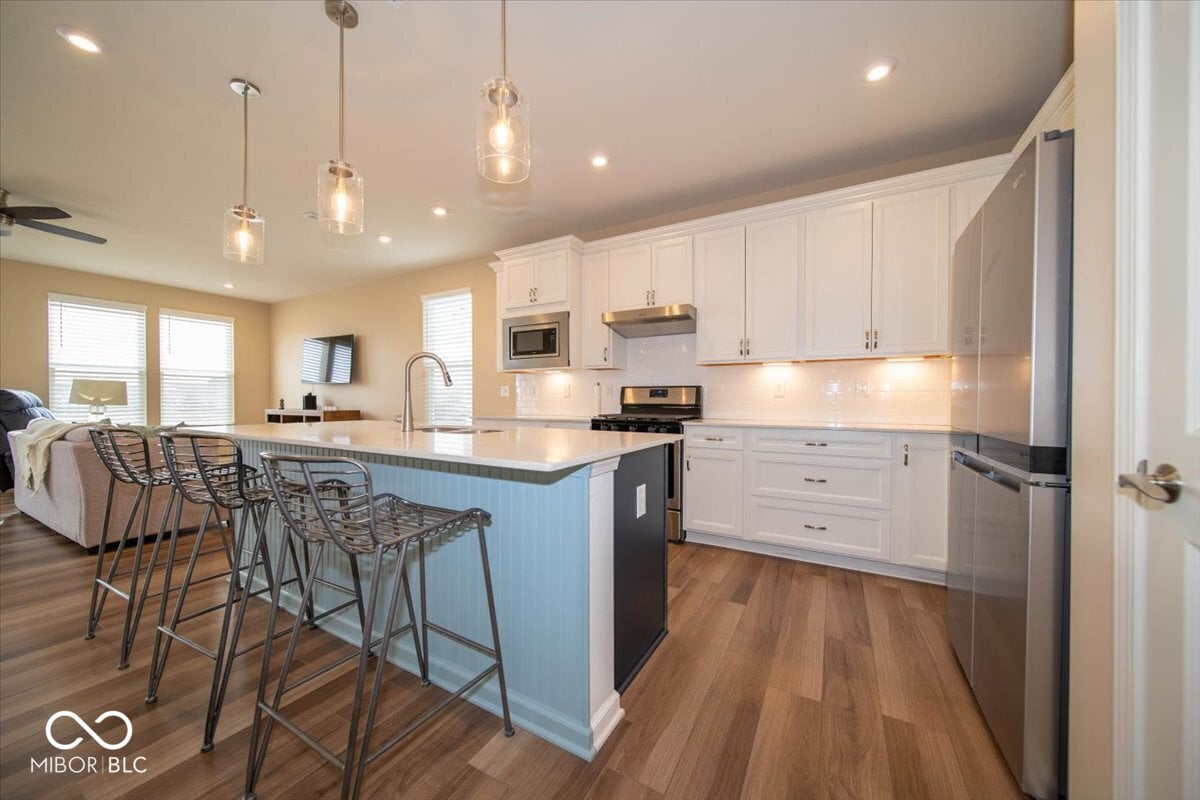 Modern renovated kitchen with island and stainless appliances.