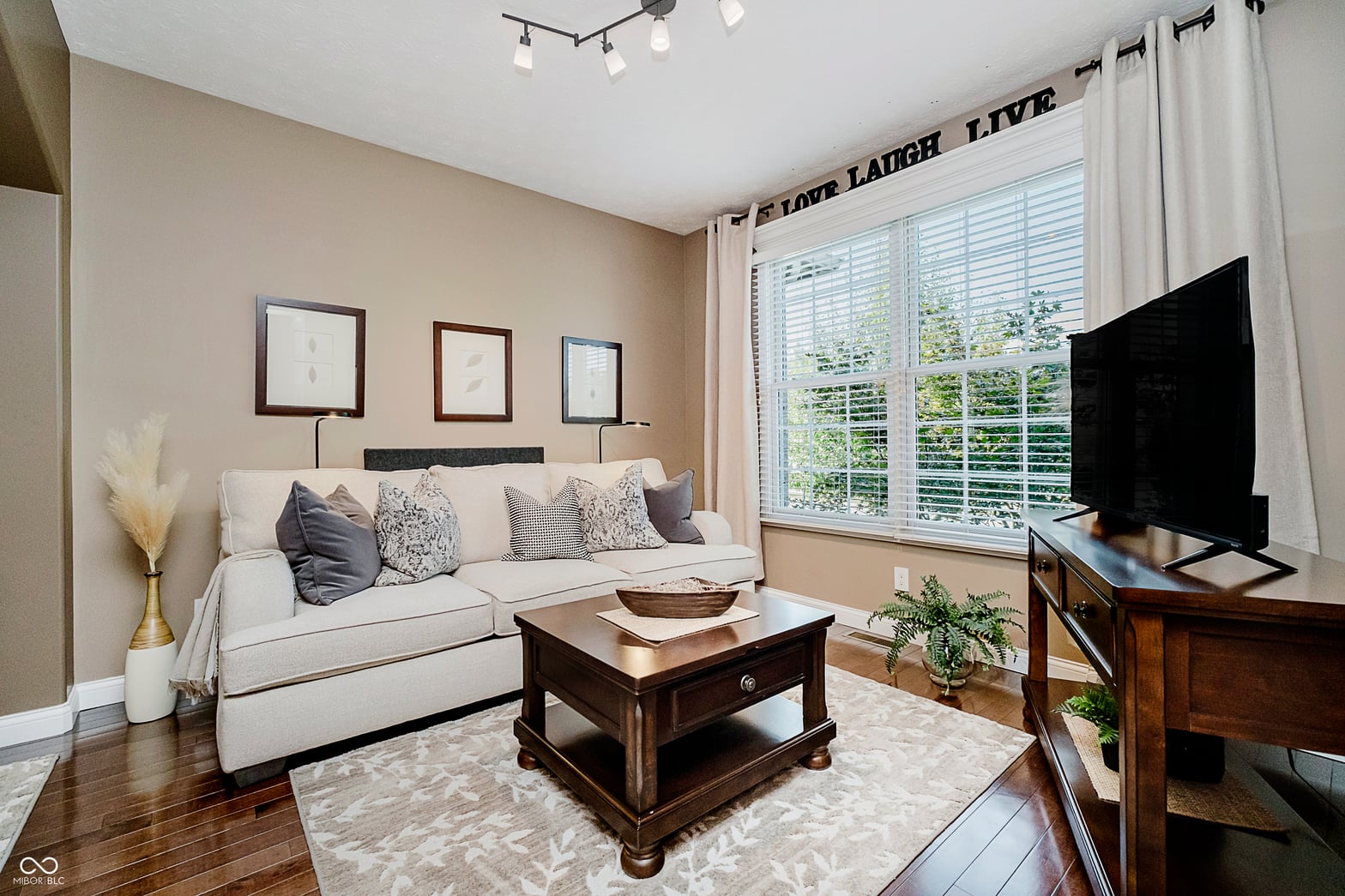 Bright living room with hardwood floors and abundant natural light.