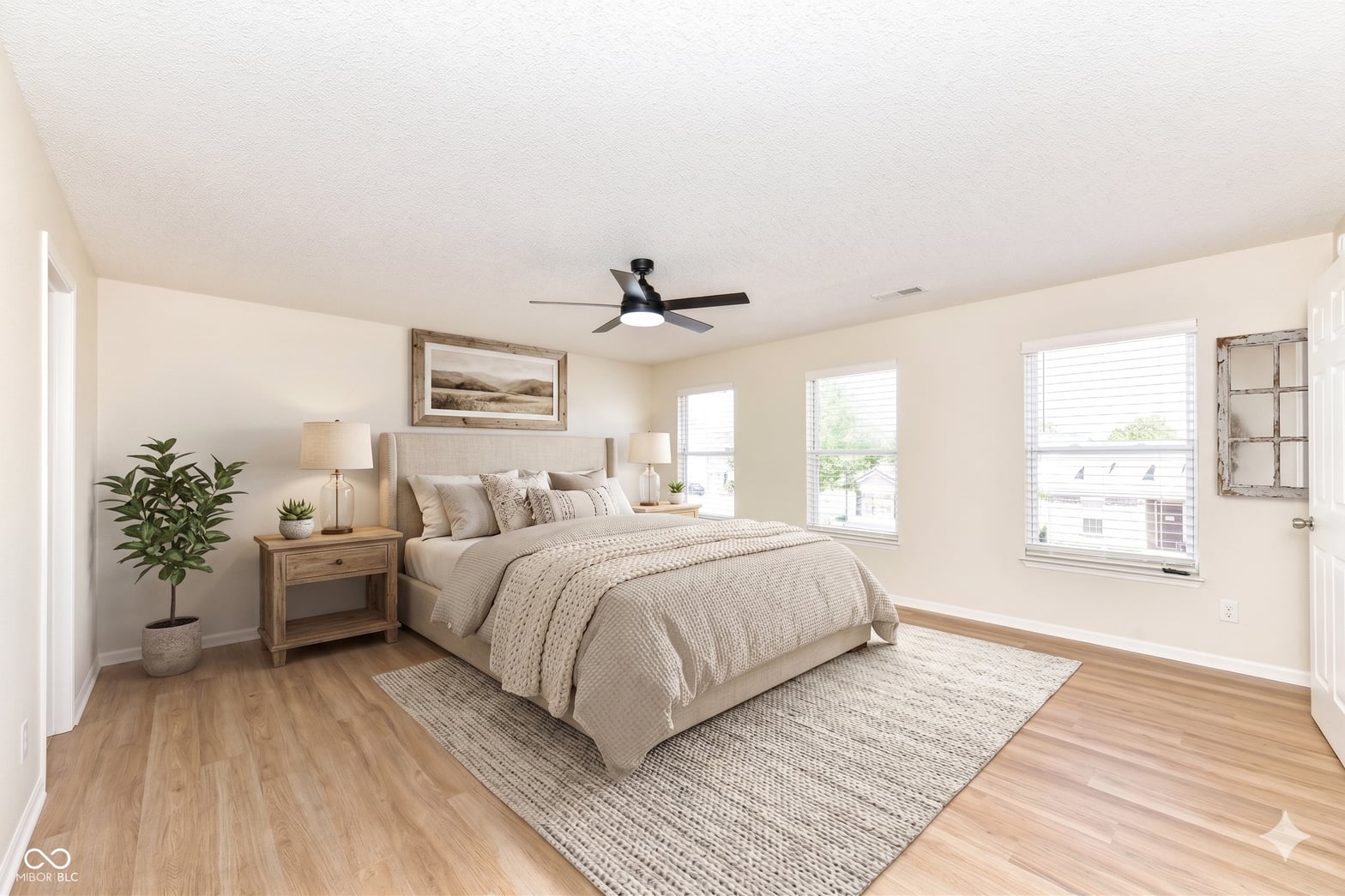 Bright primary bedroom with hardwood floors and natural light.