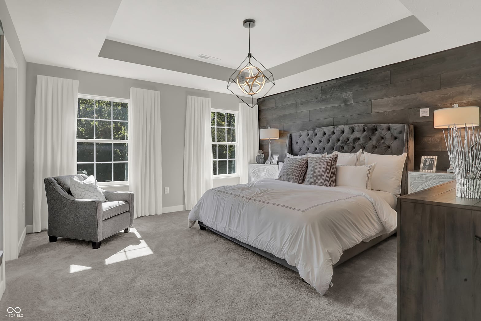 Luxurious primary suite with coffered ceilings and natural light.