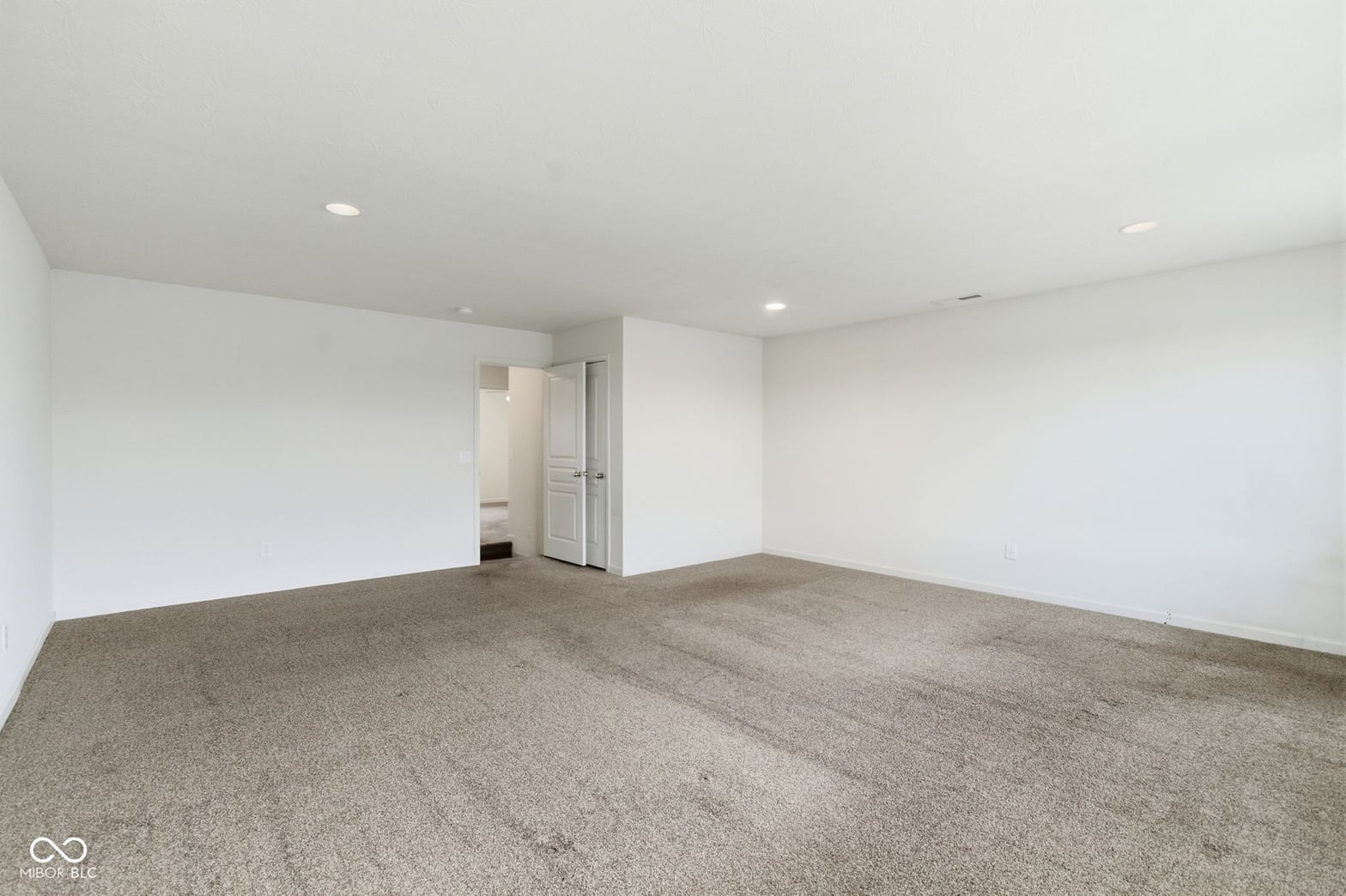 Spacious primary bedroom with ensuite and recessed lighting.