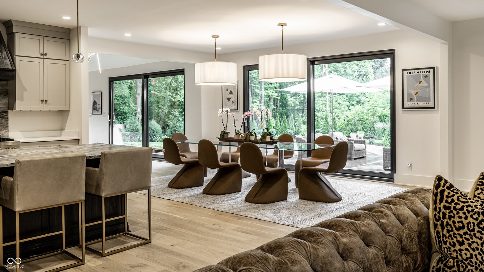 Modern dining with floor-to-ceiling glass overlooking lush forest.