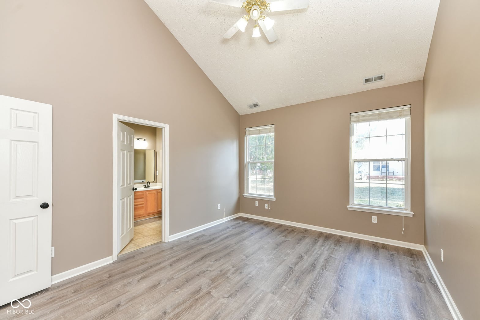 Bright primary bedroom with vaulted ceilings and ensuite.