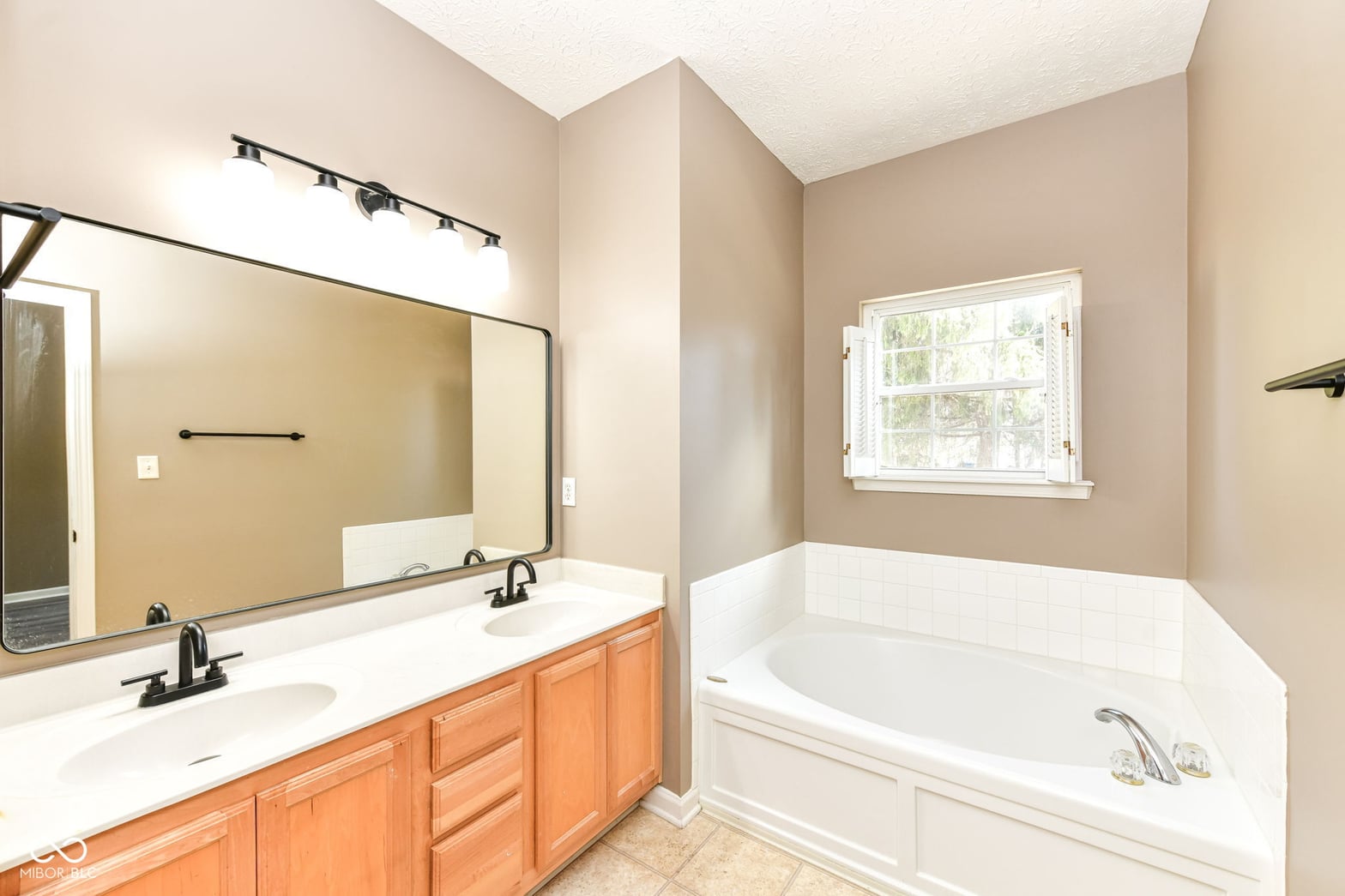 Spacious primary bath with dual vanity and soaking tub.