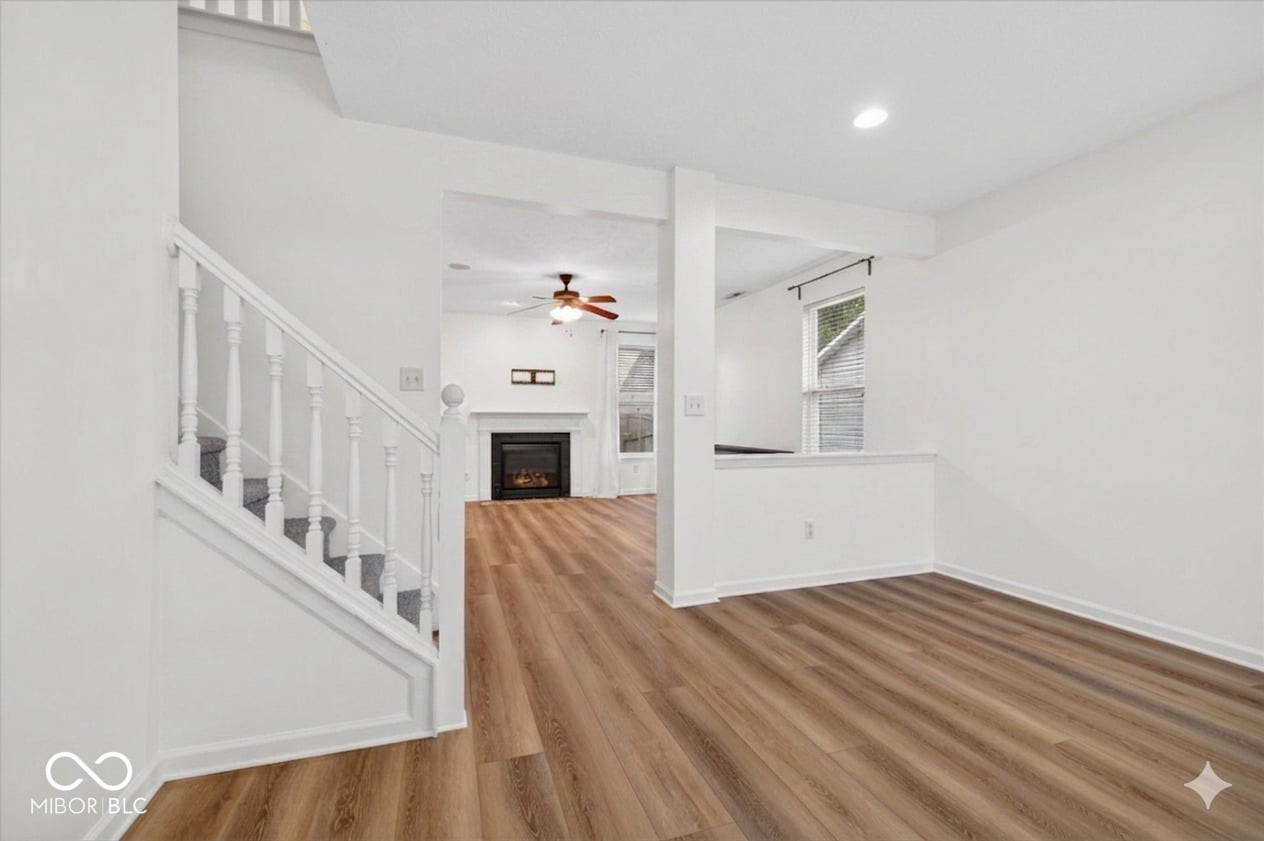 Bright open living space with fireplace and hardwood floors.