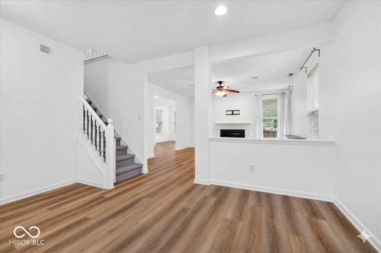 Bright open living space with fireplace and hardwood floors.
