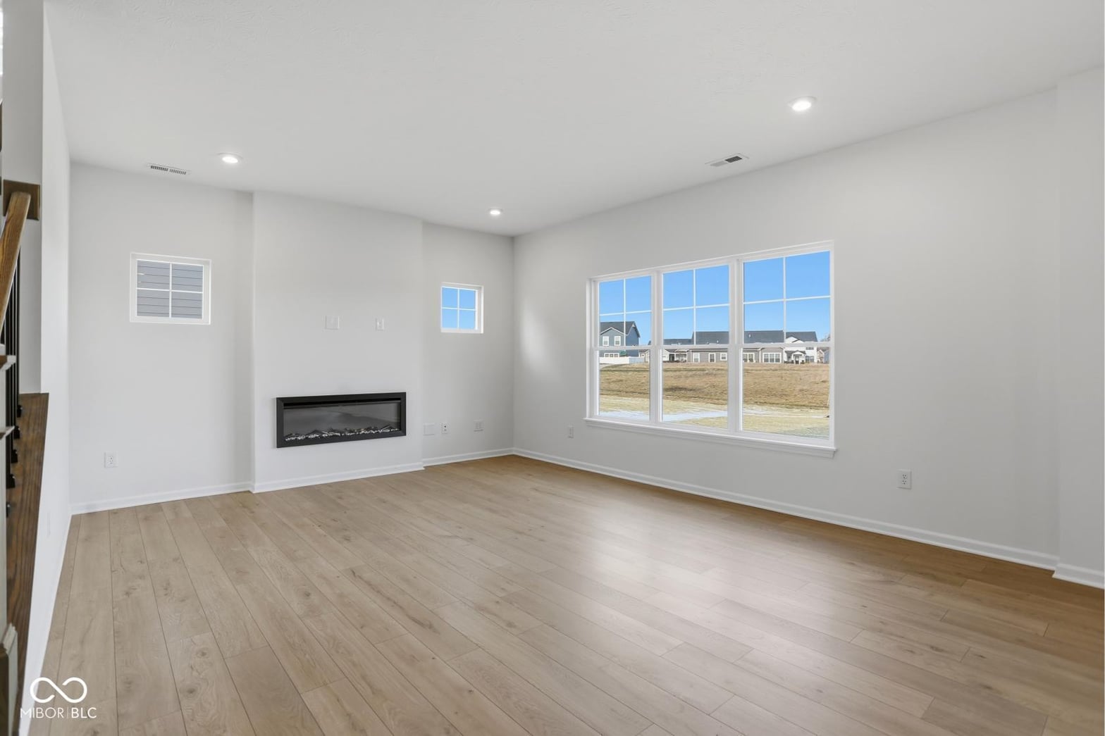 Bright family room with modern linear fireplace and expansive windows.