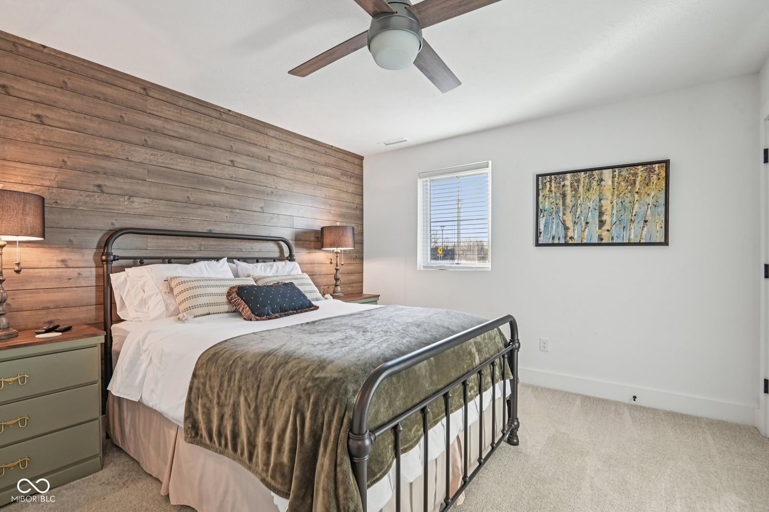 Rustic wood accent wall with modern metal bed frame.