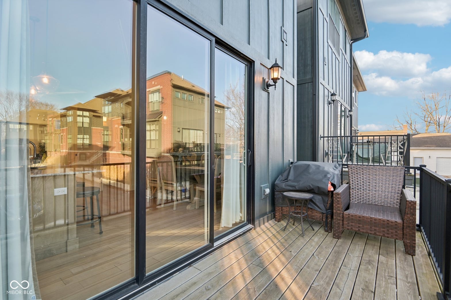 Modern deck with expansive glass doors and urban views.