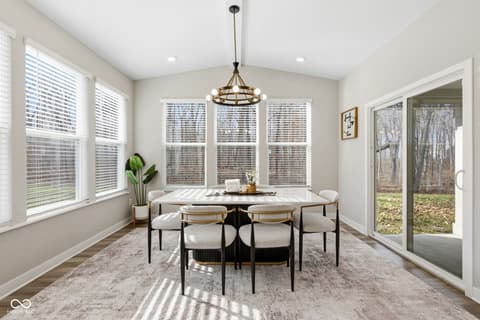 Dining room at 15546 Senita Lane, Fishers, IN — Bright dining room with multiple windows and glass doors.