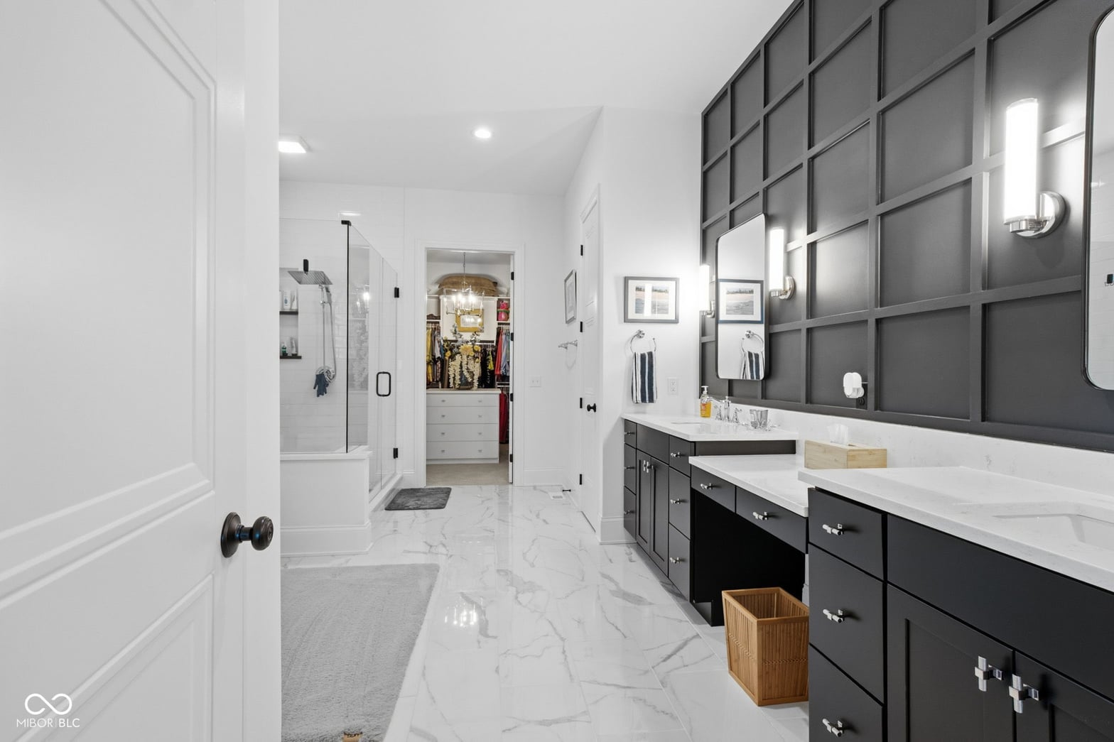 Luxurious primary bath with dual vanity and marble floors.