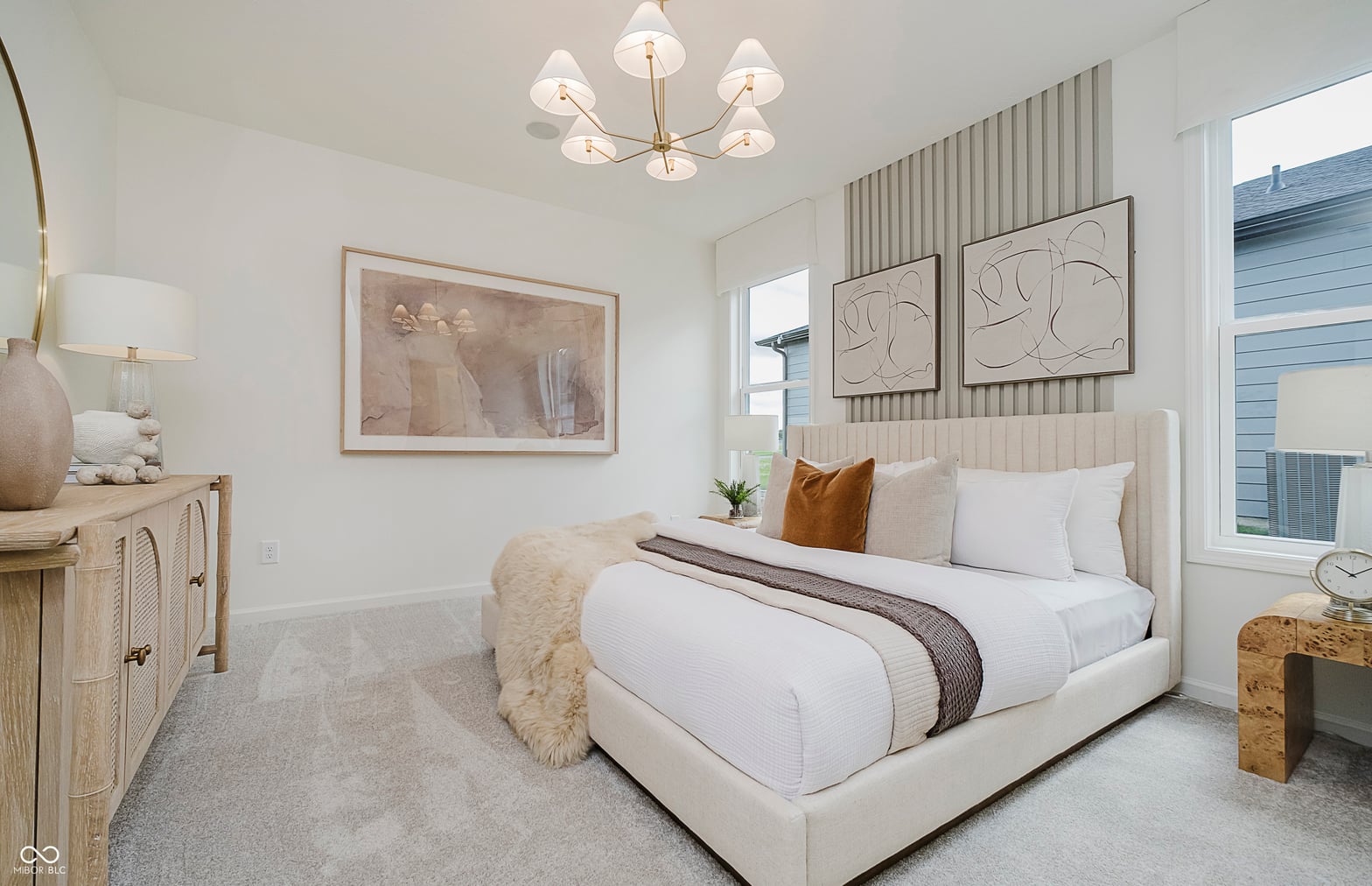 Bright, modern primary bedroom with elegant furnishings.
