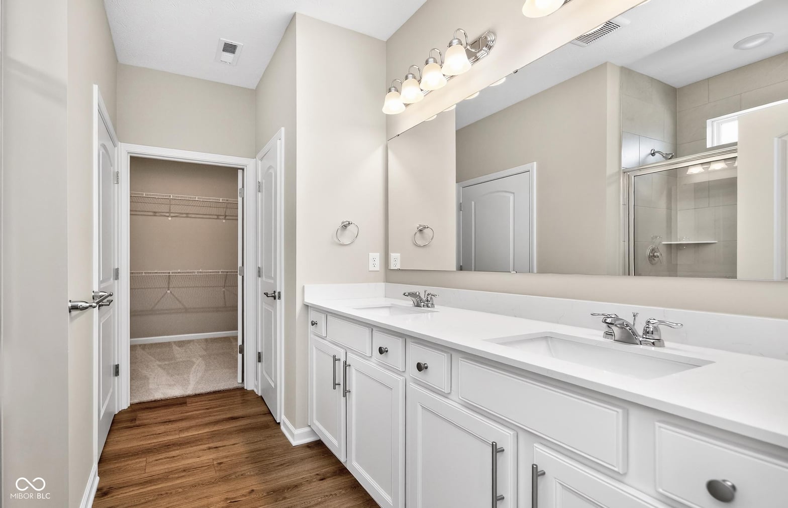 Spacious primary bath with dual vanity and walk-in shower.