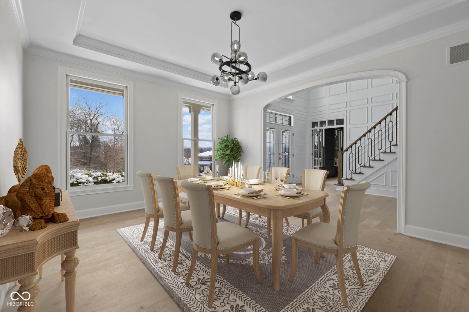 Bright dining room with water views and coffered ceiling.