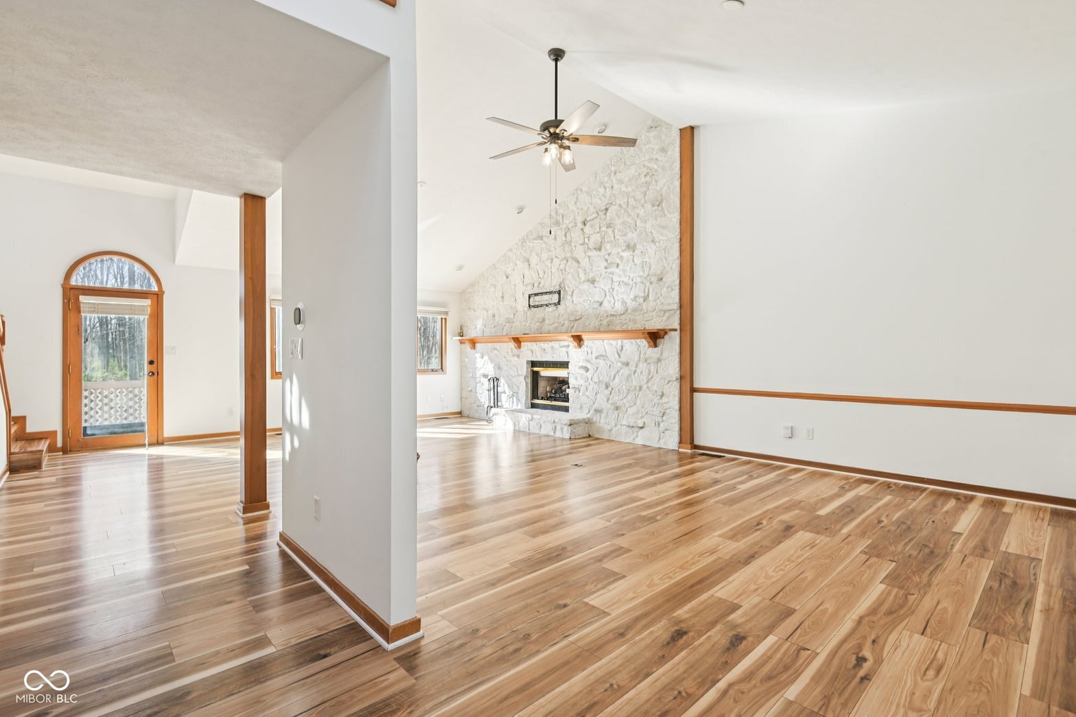 Spacious living room with marble fireplace and hardwood floors.