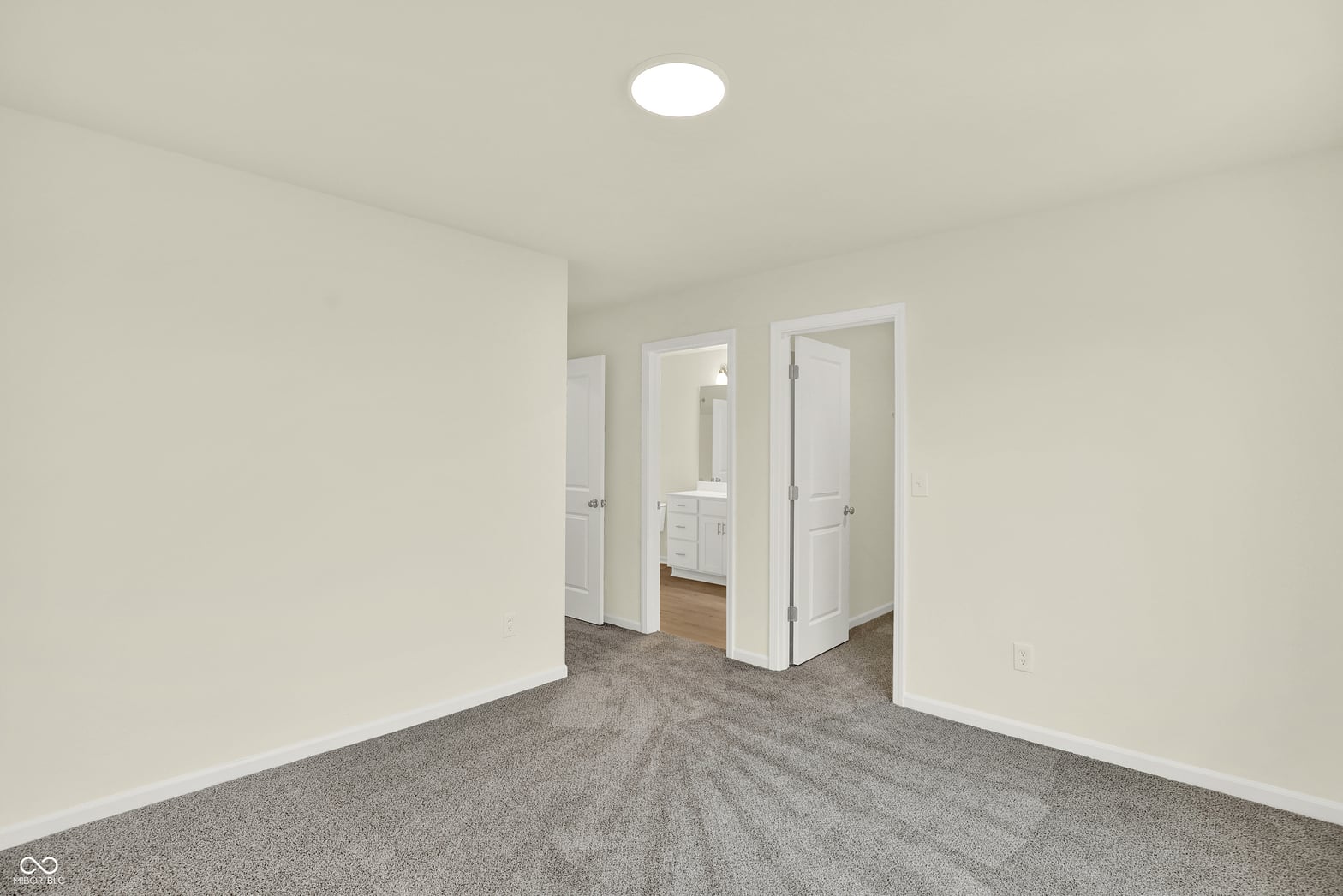 Bright primary bedroom with ensuite bathroom access.