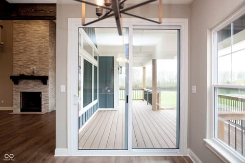 Living room at 13562 Creekridge Lane, Fishers, IN — Bright open living with fireplace and expansive deck access.