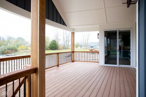 Outdoor living area at 13562 Creekridge Lane, Fishers, IN — Spacious covered deck with scenic water and yard views.