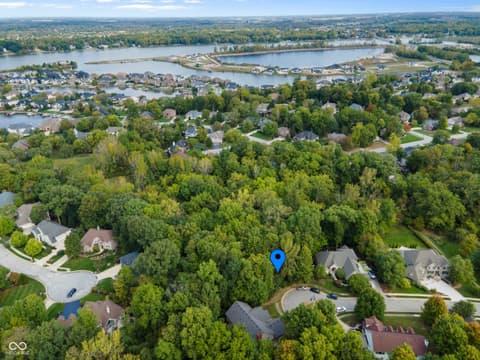 Aerial view at 13562 Creekridge Lane, Fishers, IN — Wooded lakefront lot in prestigious waterfront community.