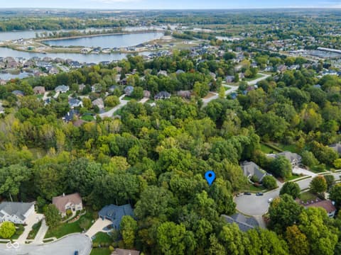Aerial view at 13562 Creekridge Lane, Fishers, IN — Wooded waterfront estate with panoramic lake views.