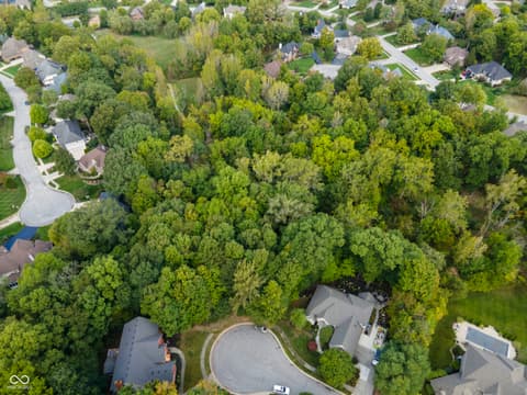 Aerial view at 13562 Creekridge Lane, Fishers, IN — Secluded wooded lot in established suburban community.