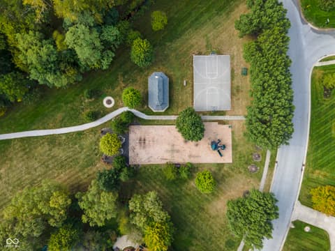 Aerial view at 13562 Creekridge Lane, Fishers, IN — Expansive grounds with sports court and mature landscaping.