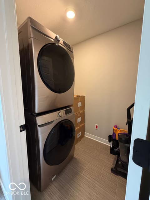Laundry room at 19994 Edwick Drive, Westfield, IN — Modern laundry room with stacked stainless steel appliances.