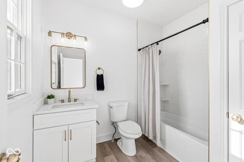 Bathroom at 10380 Spring Highland Drive, Indianapolis, IN — Bright, modern bathroom with marble and brass accents.