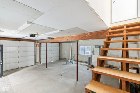 Garage at 38 Homestead Drive, Sheridan, IN — Spacious garage with loft stairs and natural light.