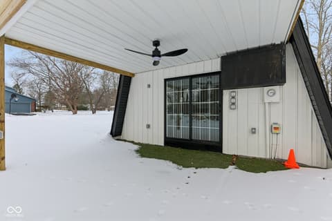 Outdoor living area at 38 Homestead Drive, Sheridan, IN — Modern covered patio with black-framed glass doors.