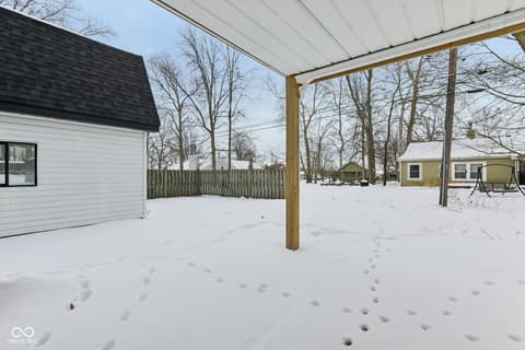 Outdoor living area at 38 Homestead Drive, Sheridan, IN — Spacious covered patio with mature trees and fenced yard.