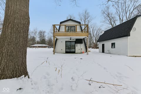 Front exterior at 38 Homestead Drive, Sheridan, IN — Unique metal structure home on expansive snowy grounds.