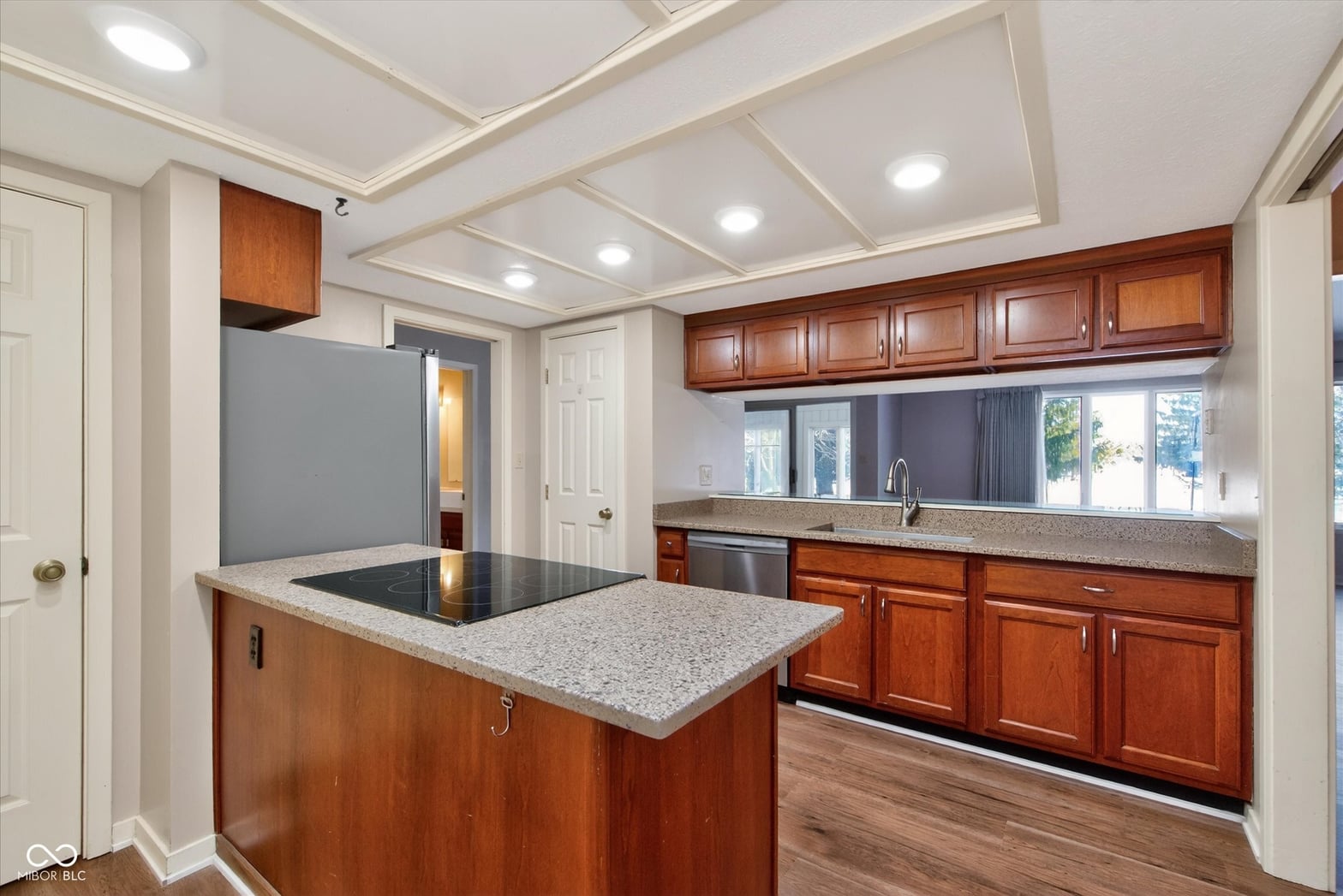 Spacious kitchen with cherry cabinetry and granite island.