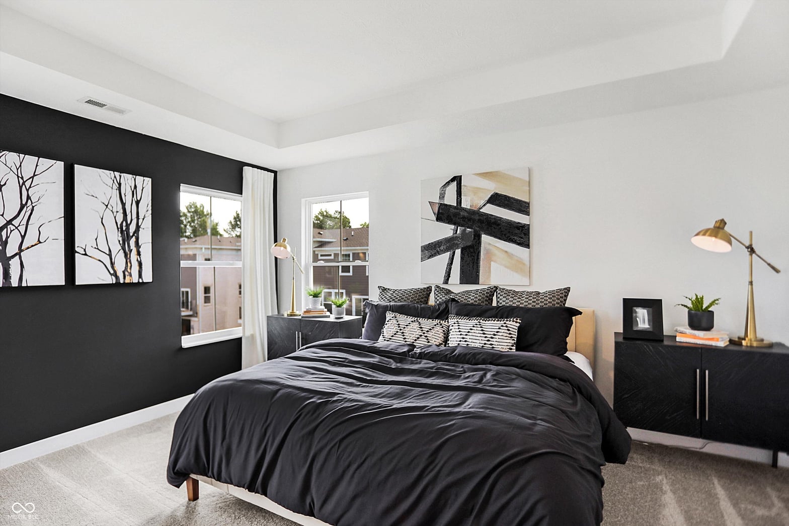 Bright contemporary primary suite with balcony and accent wall.