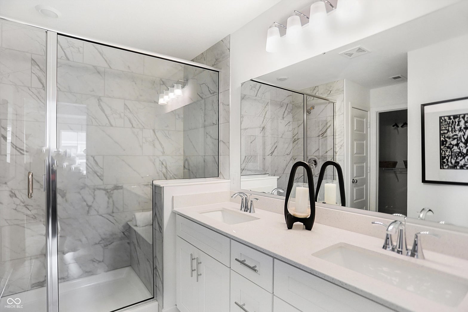 Luxurious primary bath with marble shower and dual vanity.
