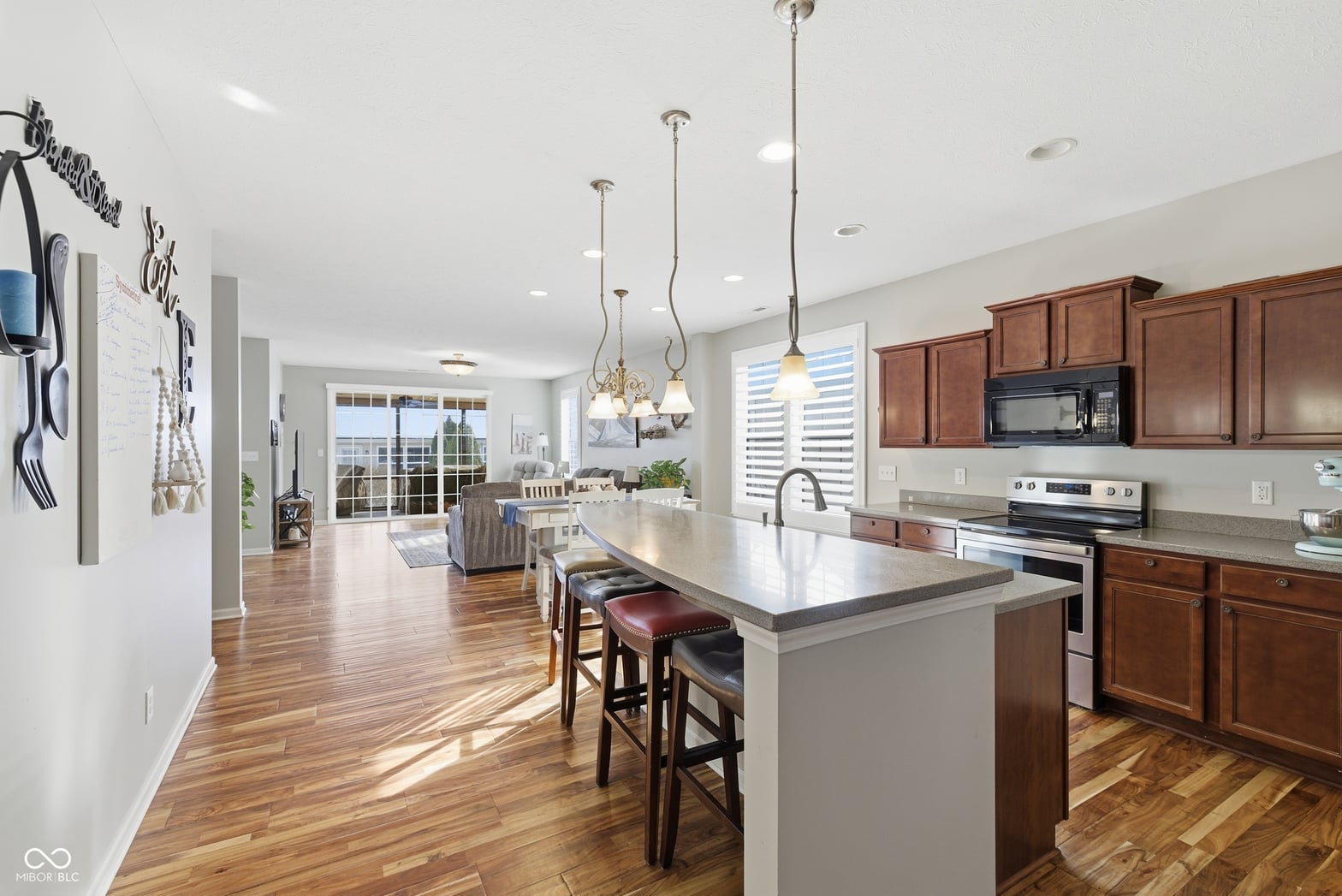 Bright open kitchen with island and hardwood floors.