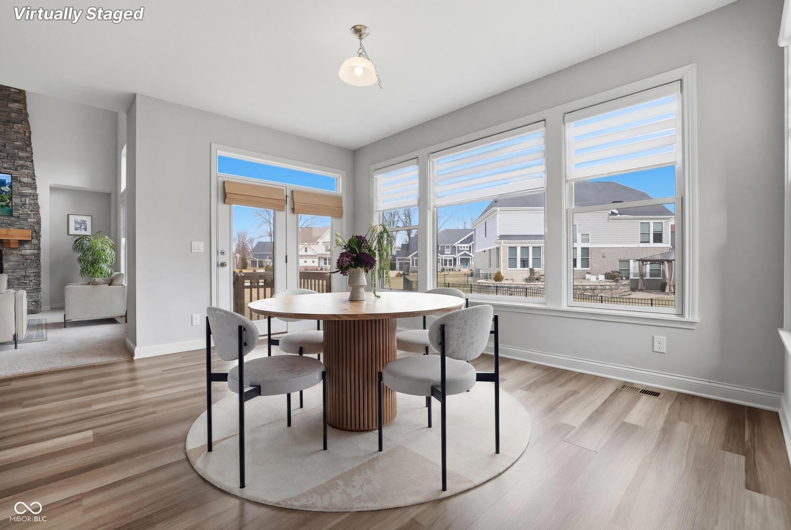 Bright modern dining room with expansive windows and hardwood floors.