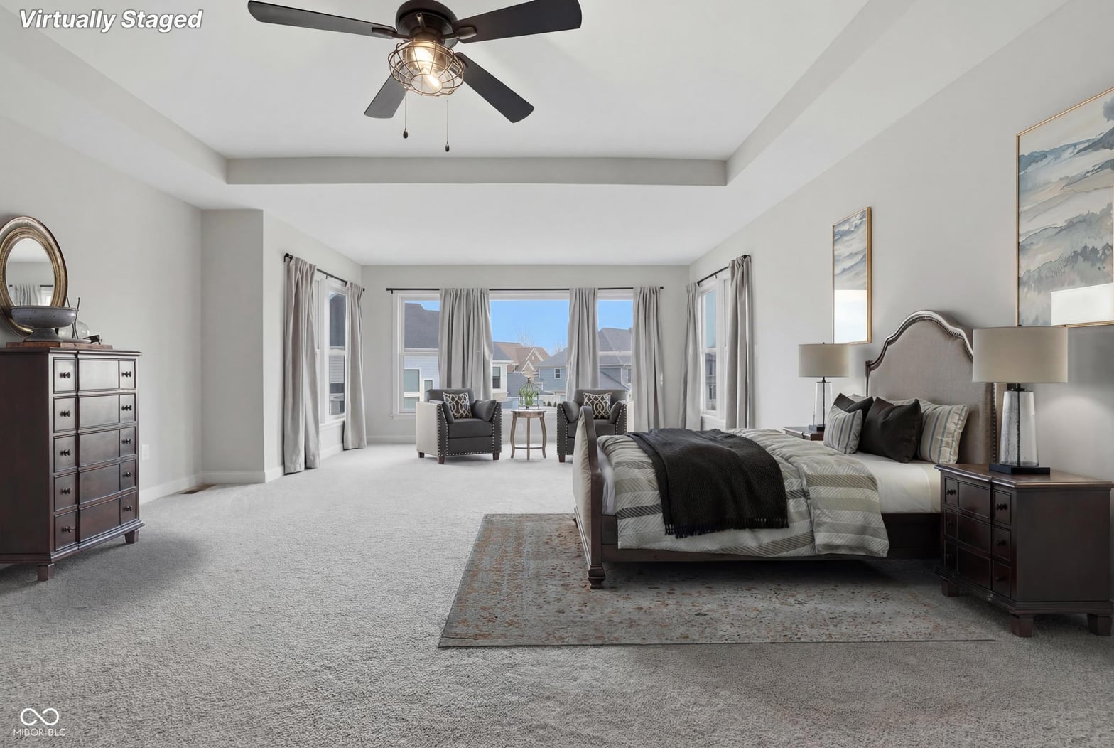 Luxurious primary suite with expansive windows and sitting area.