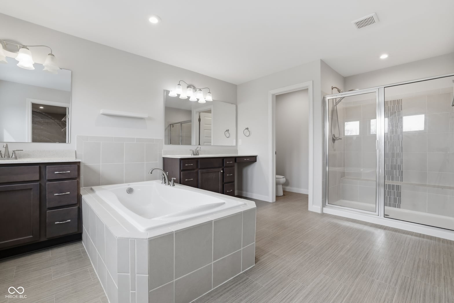 Luxurious primary bath with soaking tub and dual vanities.