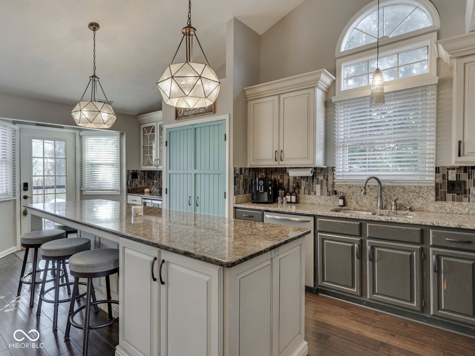 Stunning renovated kitchen with two-tone cabinetry and granite island.