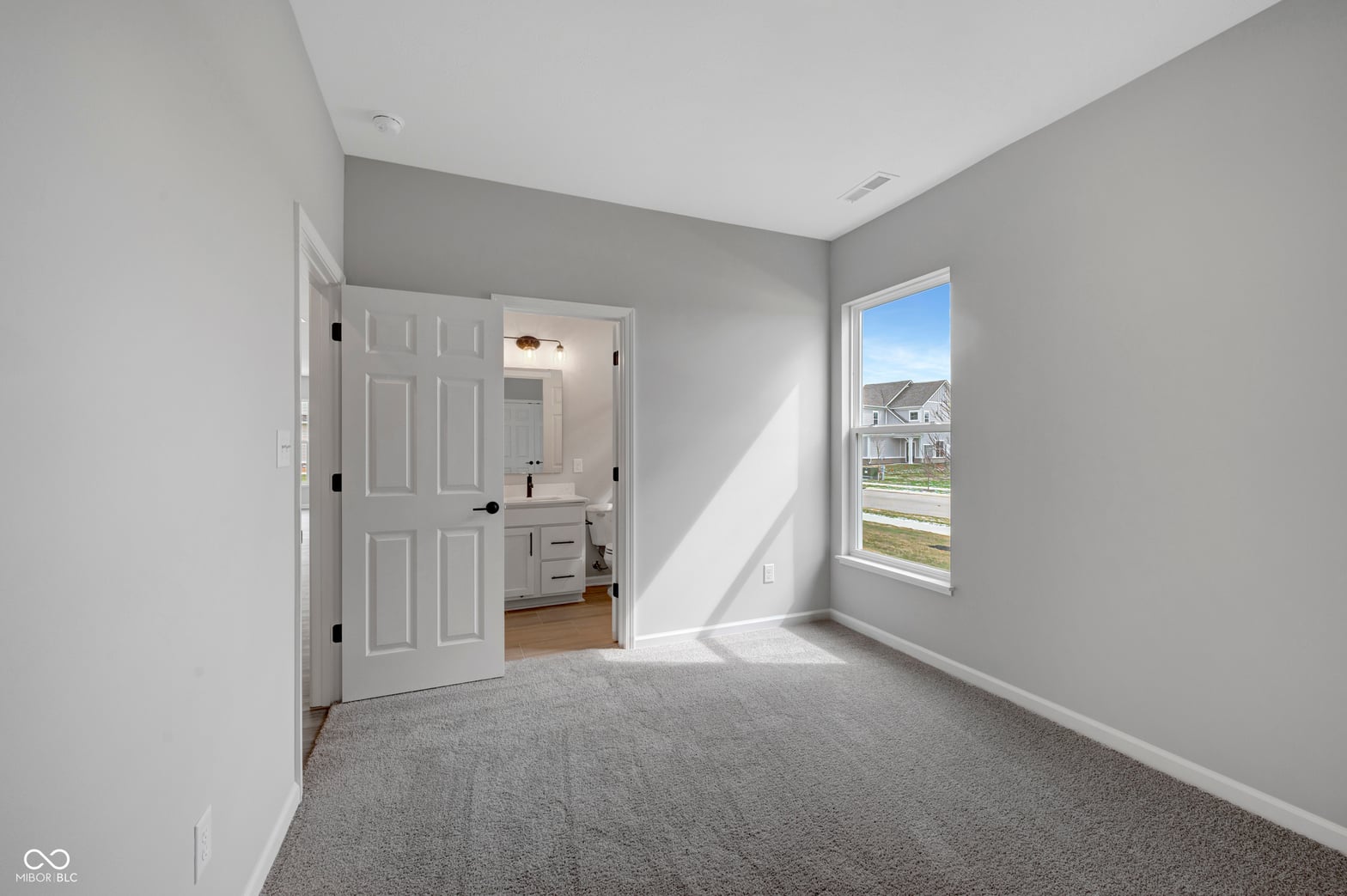 Bright primary suite with ensuite bathroom and walk-in closet.