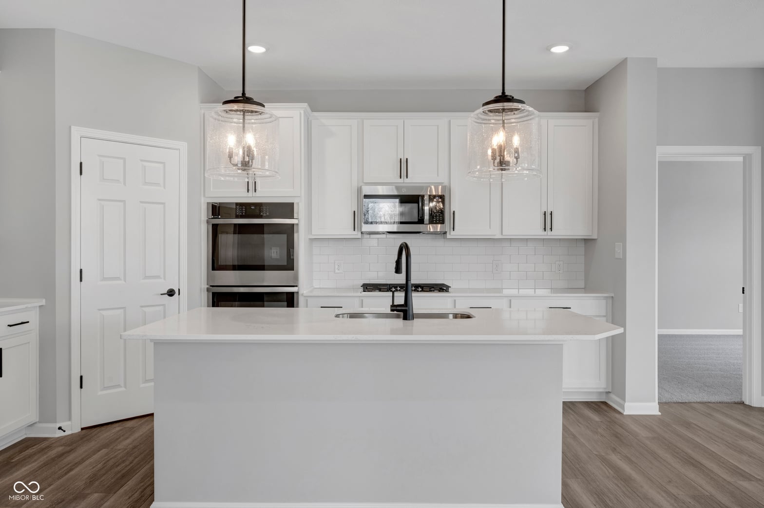 Bright modern kitchen with island and premium stainless steel appliances.
