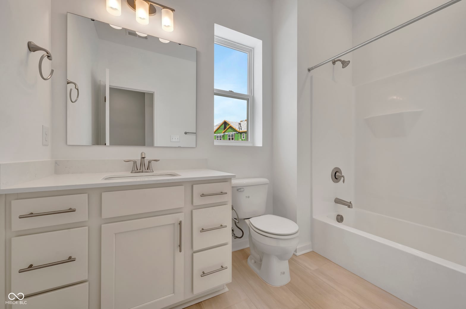 Bright modern primary bath with dual vanity and soaking tub.