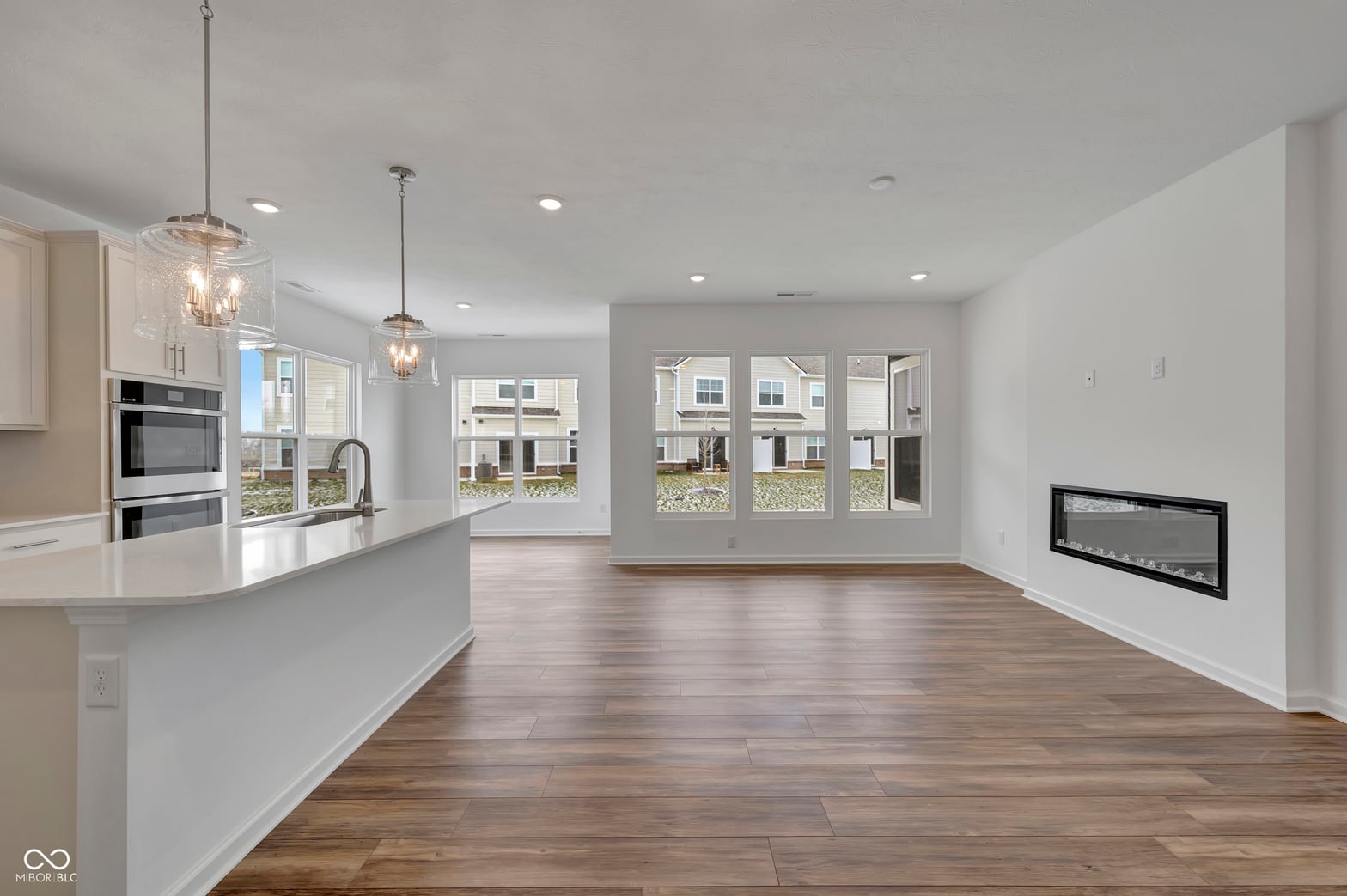 Bright open-concept living with modern fireplace and views.